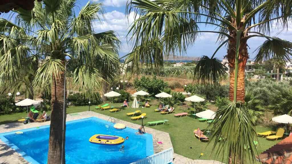 Swimming pool surrounded by palm trees and sun loungers in Gerani, Crete