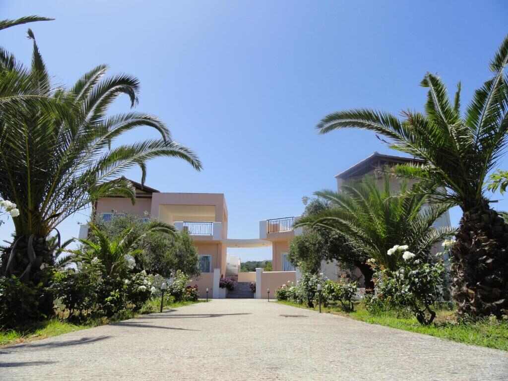 Entrance driveway and buildings of Pardalakis Studios framed by palm trees