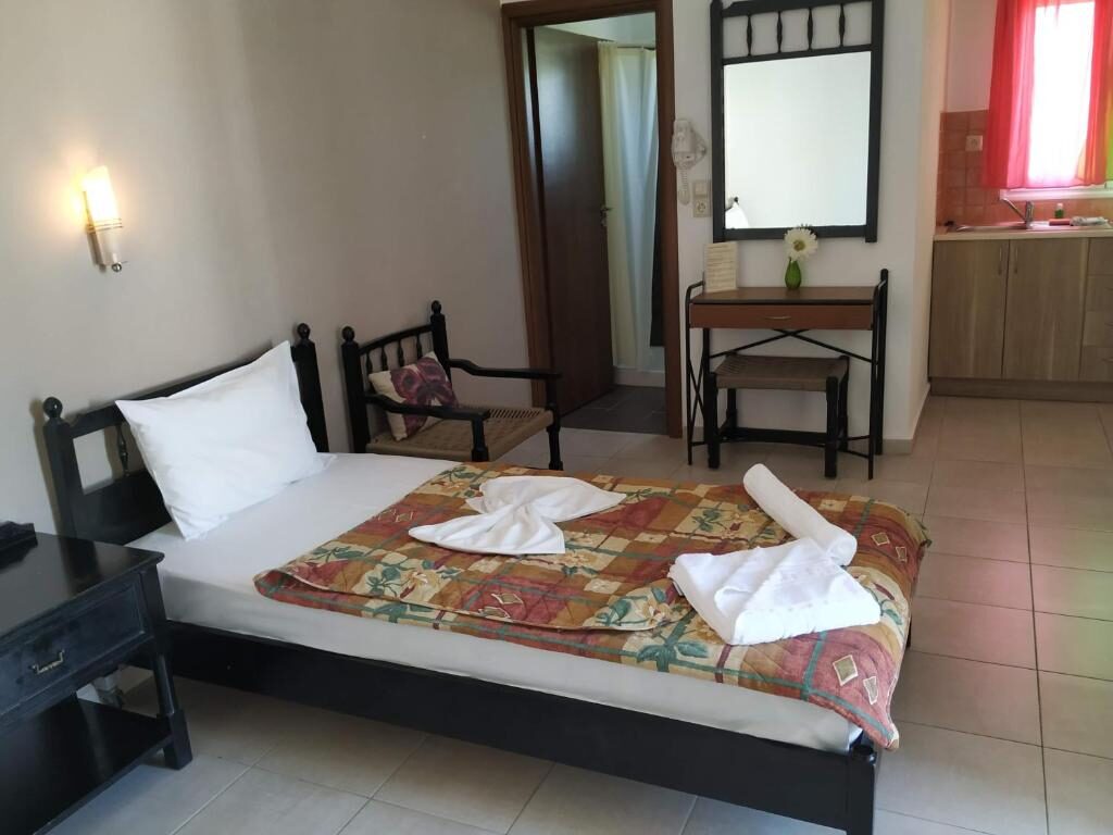 Apartment bedroom with double bed and kitchen area